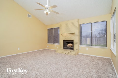 A room with a fireplace and a ceiling fan.