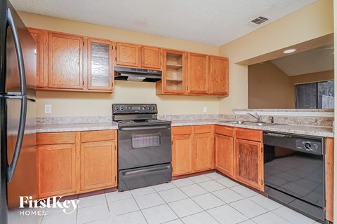 A kitchen with wooden cabinets and a stainless steel refrigerator.
