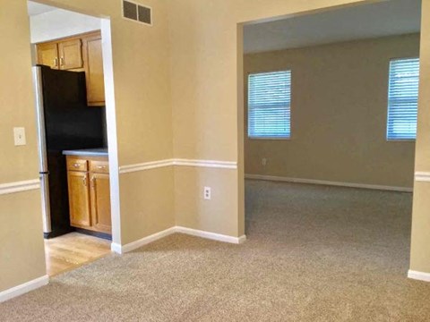A kitchen area with a refrigerator and cabinets.