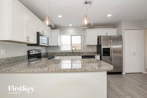 A kitchen with a granite countertop and a FirstKey Homes logo.