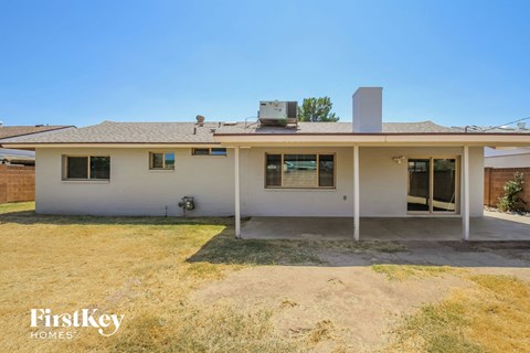 A house with a white exterior and a brown roof is for sale.