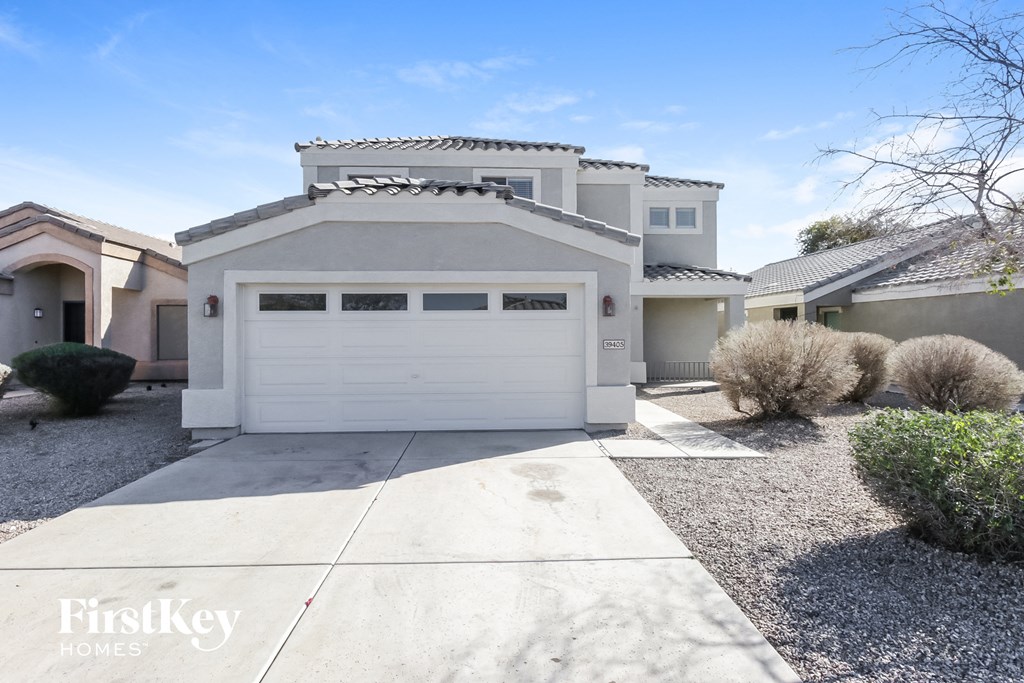 A modern house with a white garage door is for sale.