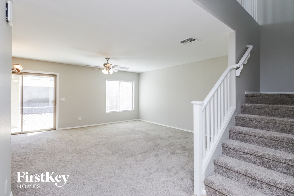 A spacious room with a staircase leading to the upper floor.