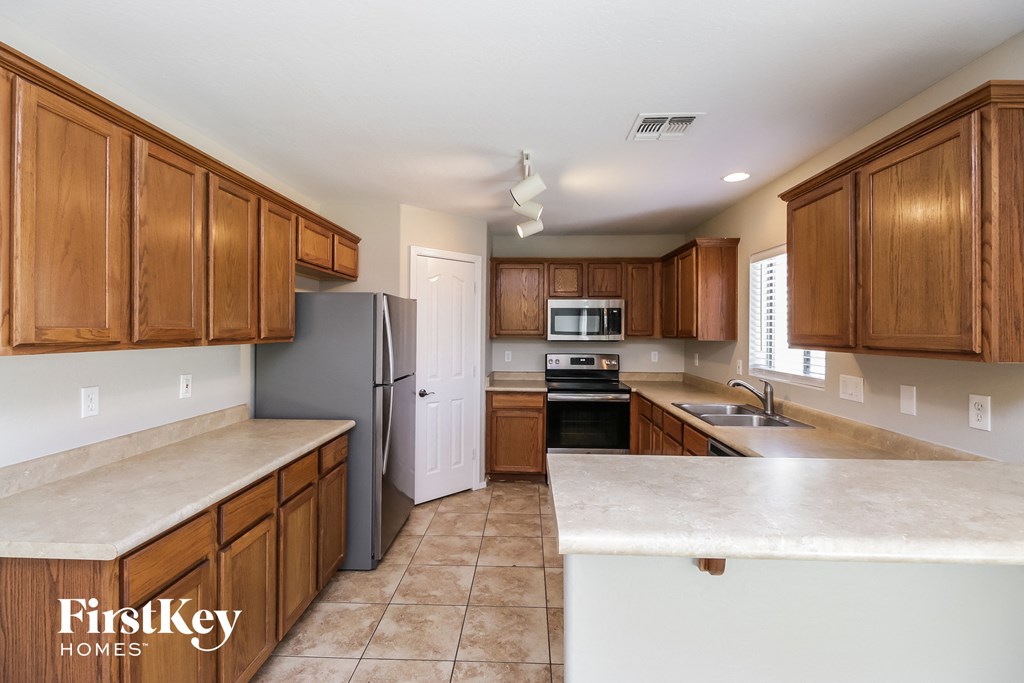A kitchen with wooden cabinets and a refrigerator.