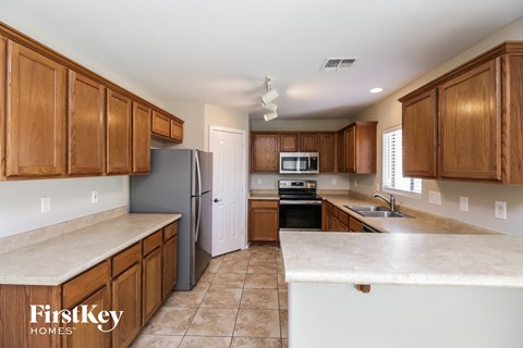 A kitchen with wooden cabinets and a refrigerator.