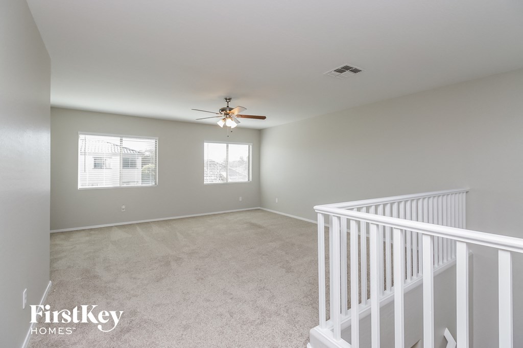 A spacious room with a ceiling fan and a window.