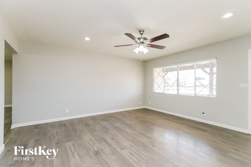 A spacious room with a ceiling fan and a window.