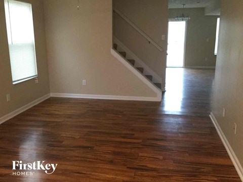 a living room with a hard wood floor and a staircase