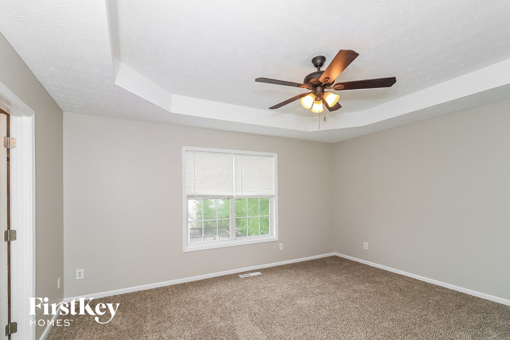 a bedroom with a ceiling fan and a window