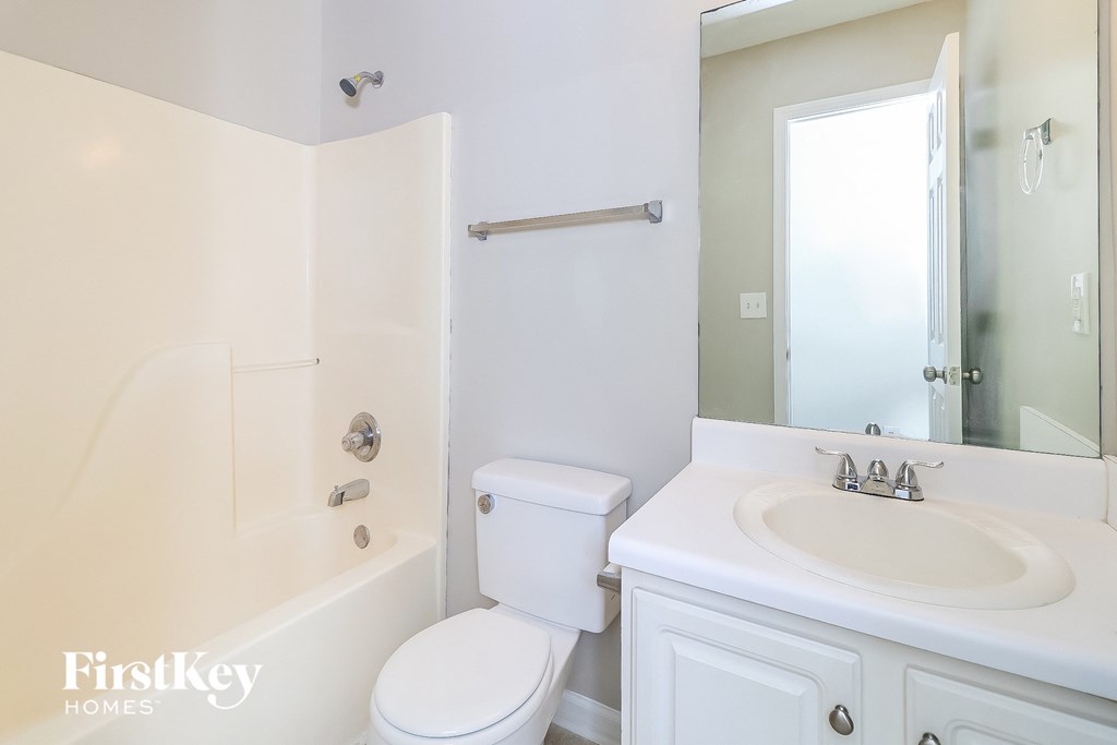 a white bathroom with a sink toilet and shower