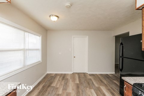 a kitchen with a refrigerator and a window and a door