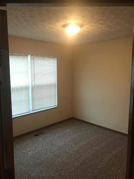 an empty room with a window and a light on the ceiling