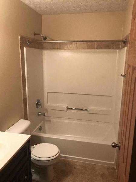 a white bathroom with a toilet and a shower