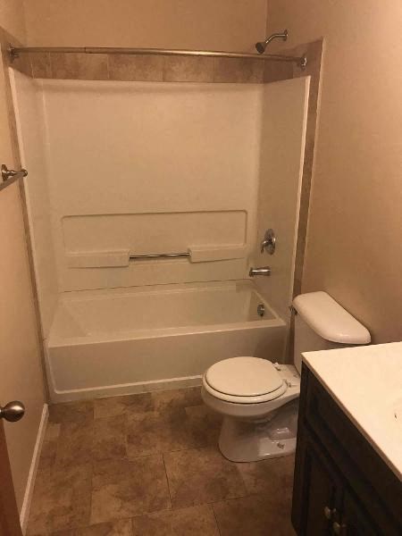 a bathroom with a toilet and a bath tub