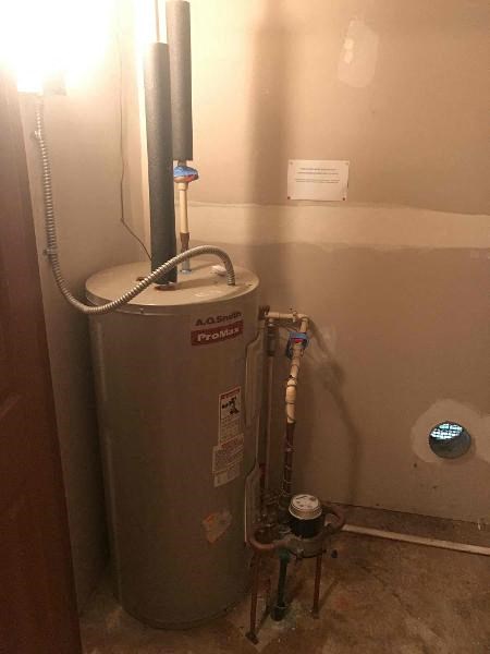 a bathroom with a water heater in the corner