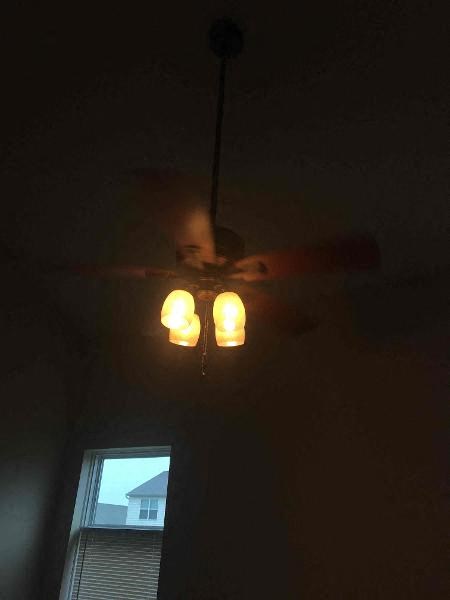 two lamps hanging from a ceiling fan in a dark room