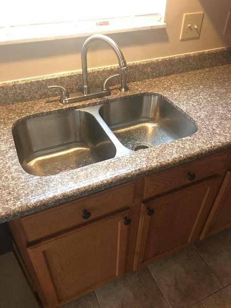 a kitchen sink with a faucet on a counter top