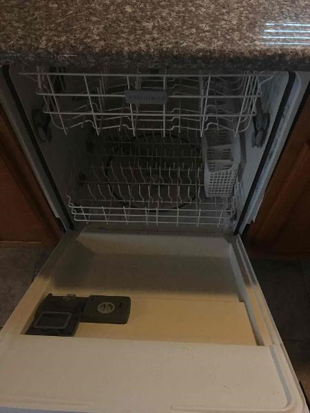 an empty dishwasher in a kitchen with the door open