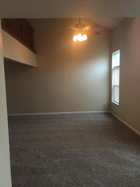 an empty room with a ceiling fan and a window