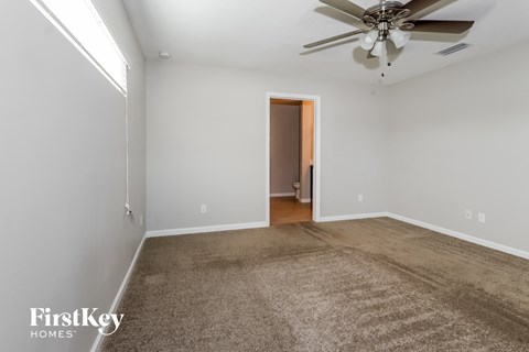 a living room with a carpet and a ceiling fan