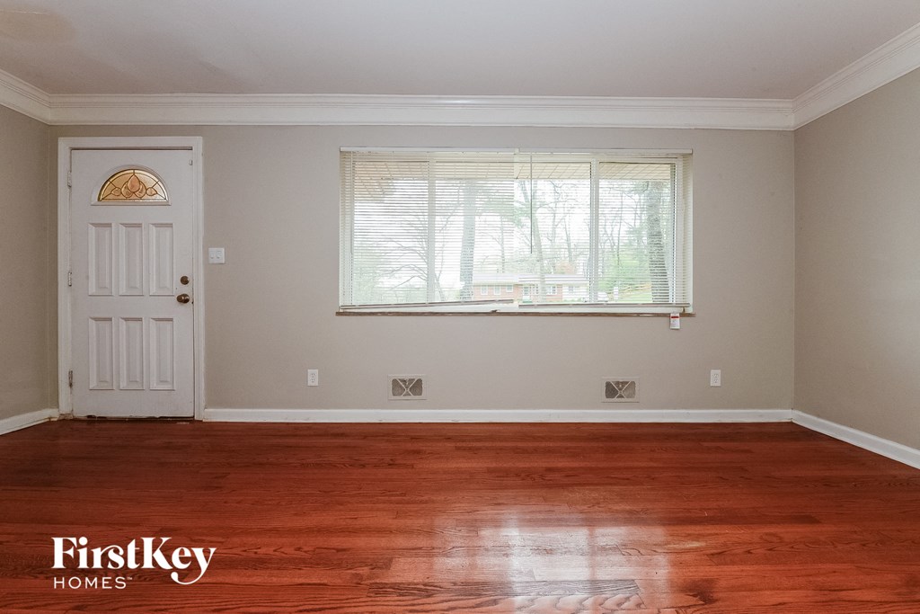 a room with wood floors and a white door and a window