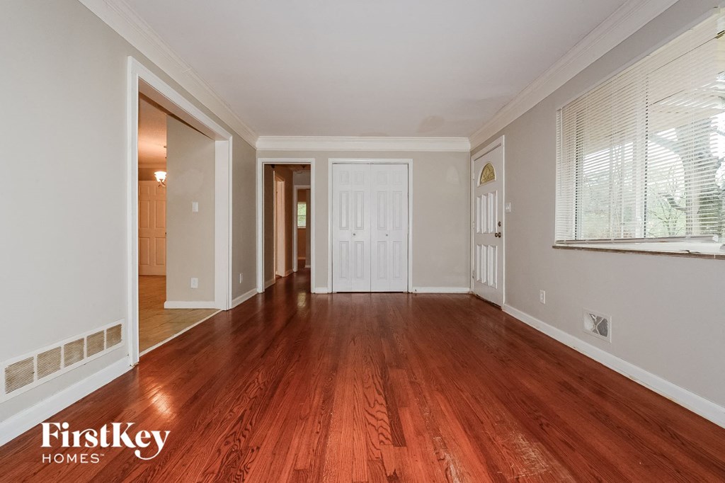 the living room and dining room with wood flooring and a large window