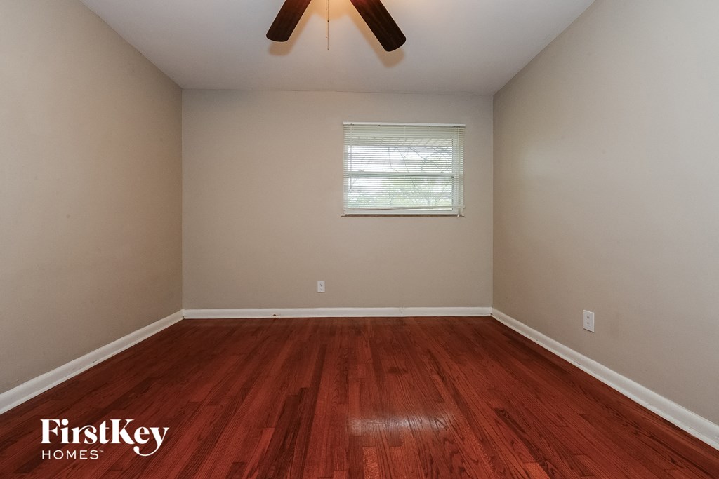 the bedroom with hardwood flooring and a ceiling fan