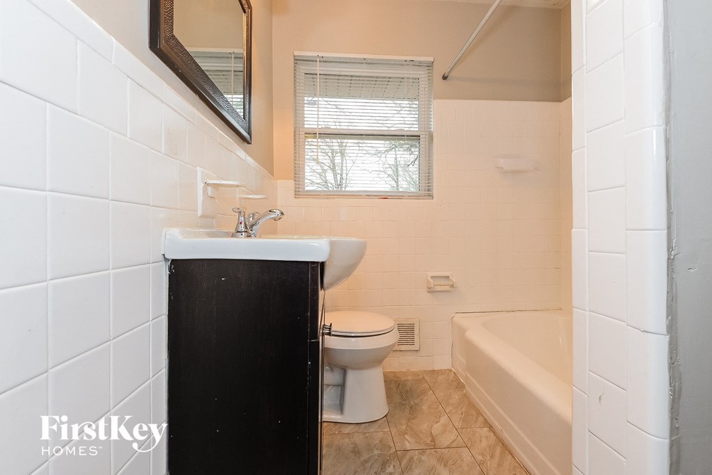 a bathroom with a toilet and a sink and a bath tub