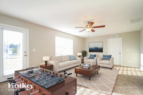 A living room with a foosball table in the middle.
