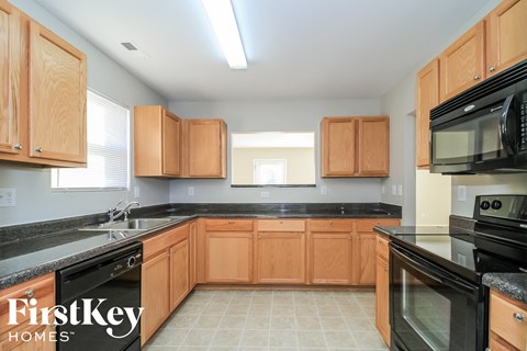 A kitchen with wooden cabinets and black appliances.
