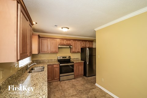 a kitchen with granite counter tops and wooden cabinets