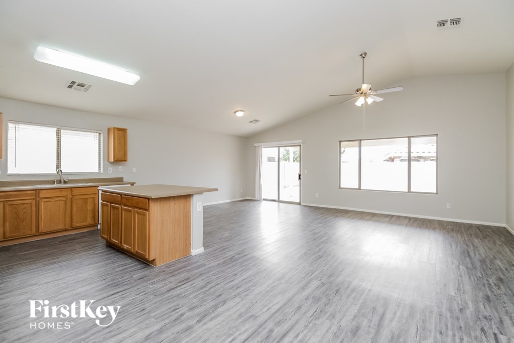 an empty kitchen and living room with wood flooring and white walls