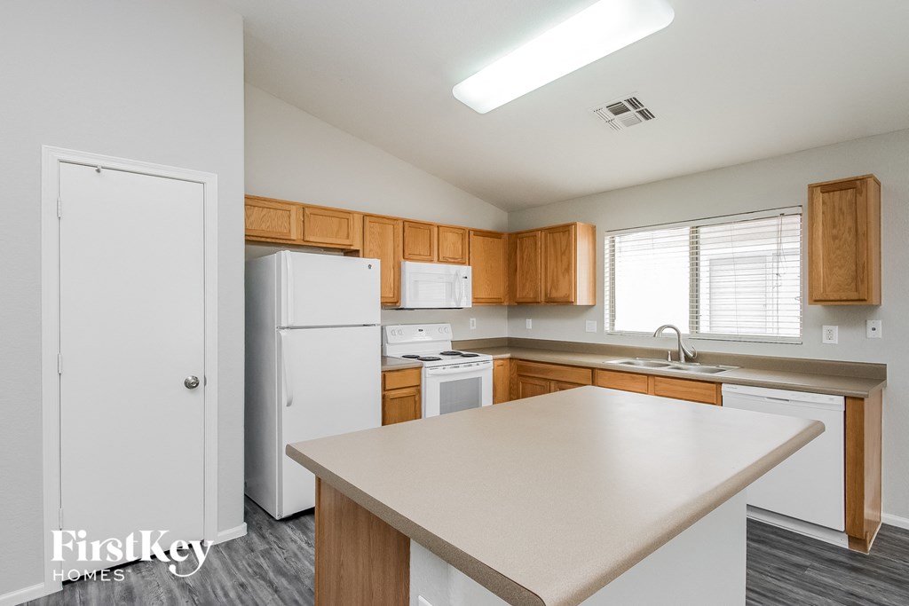 a kitchen with white appliances and wooden cabinets