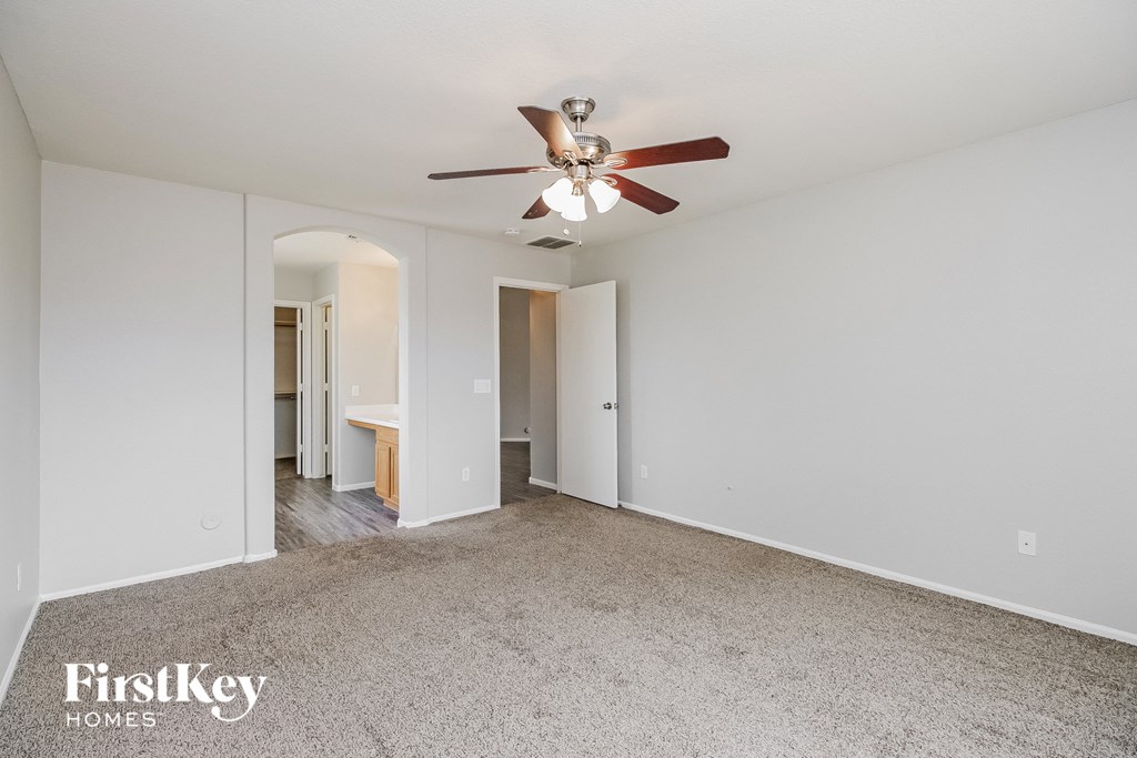a living room with white walls and a ceiling fan
