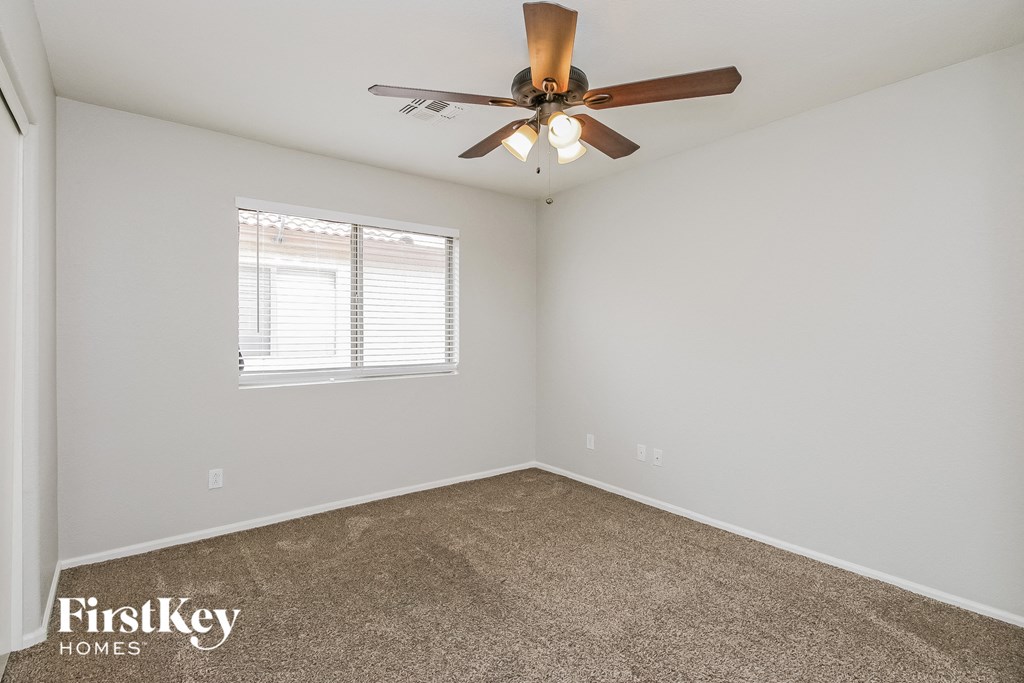 a bedroom with a ceiling fan and a window