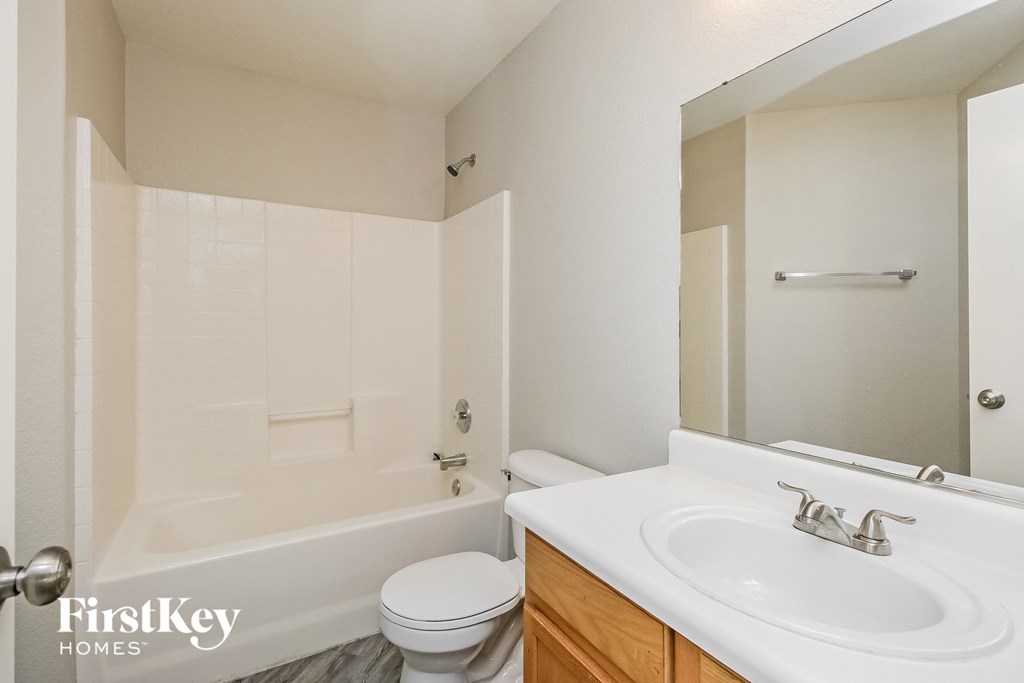 a bathroom with a sink toilet and tub and a mirror