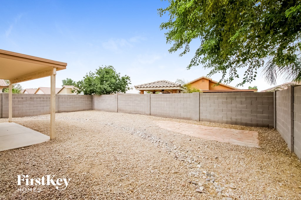 a retaining wall in a yard with a house in the background