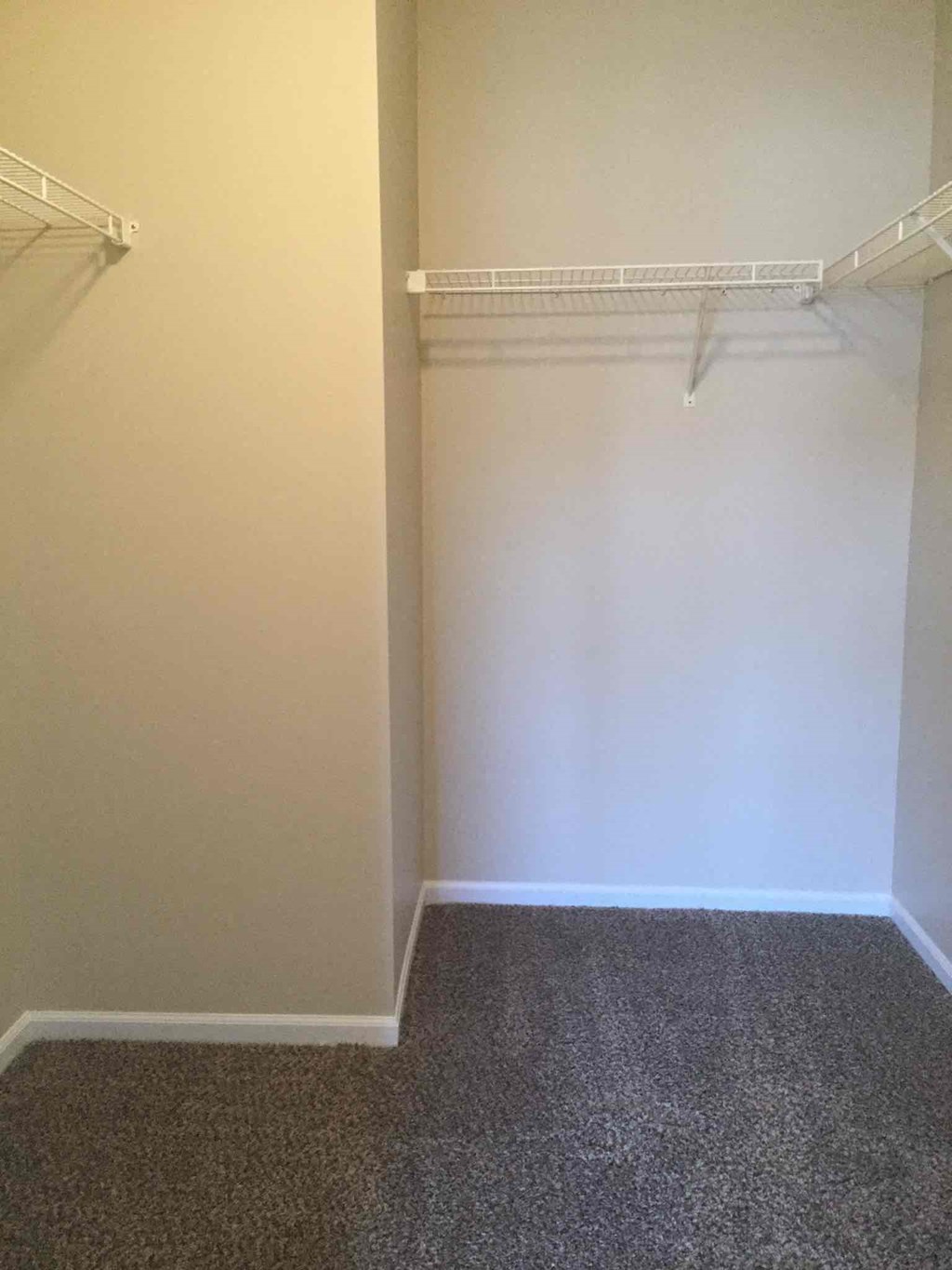 a empty closet in a room with white walls and a carpet