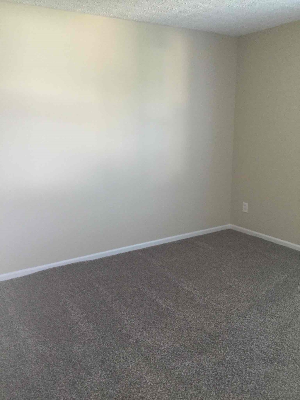 an empty room with white walls and carpet