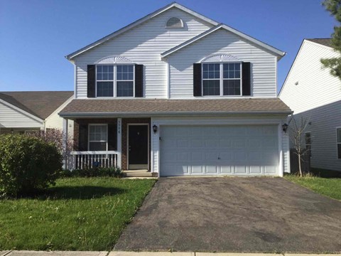 a white house with a driveway in front of it