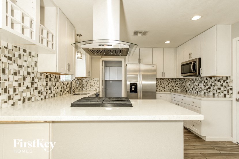 a kitchen with white cabinets and a white counter top