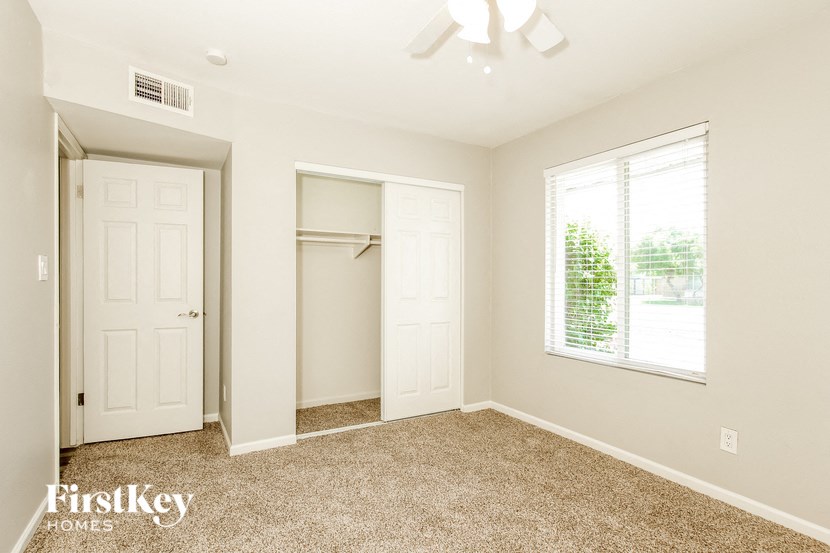 an empty bedroom with a closet and a window