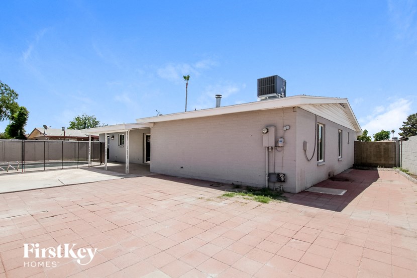 a large white house with a driveway and a fence