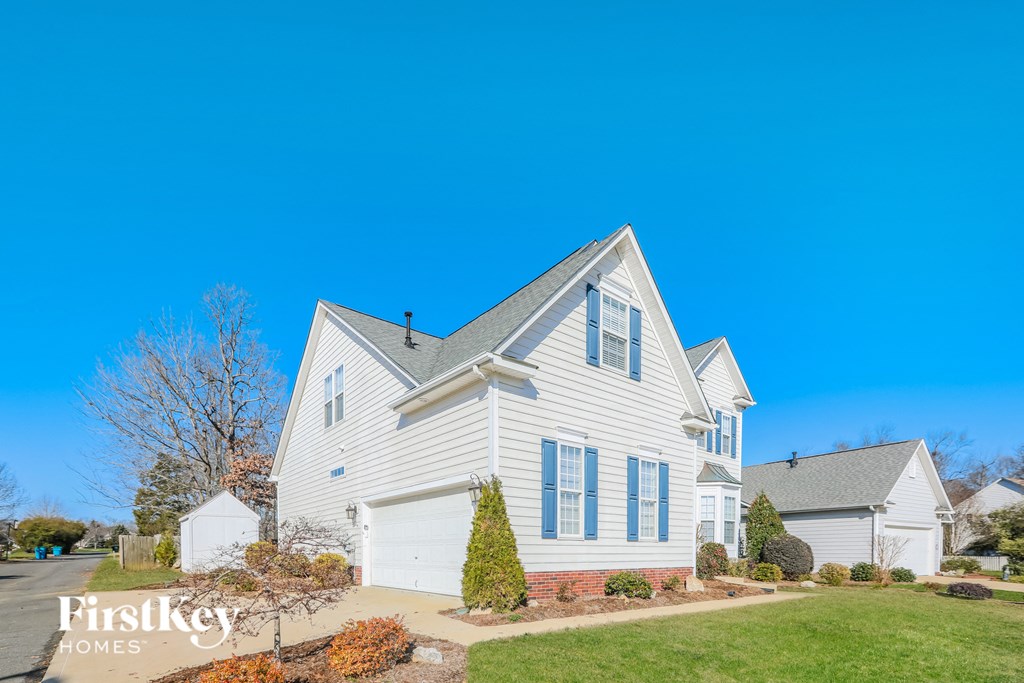 a white house with white siding and a blue sky