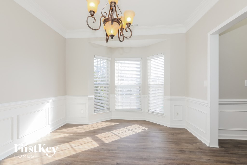 a dining room with a chandelier and three windows