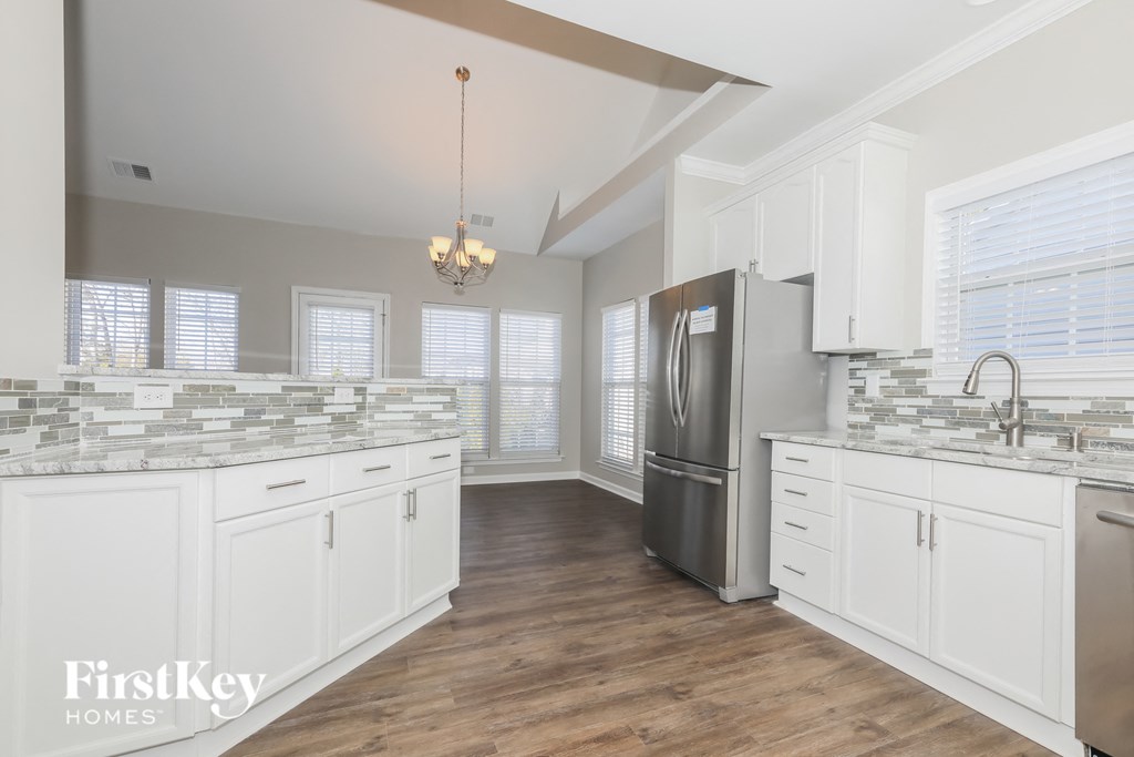 a kitchen with white cabinets and a stainless steel refrigerator