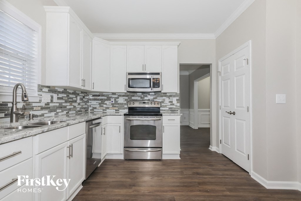 a kitchen with white cabinets and stainless steel appliances