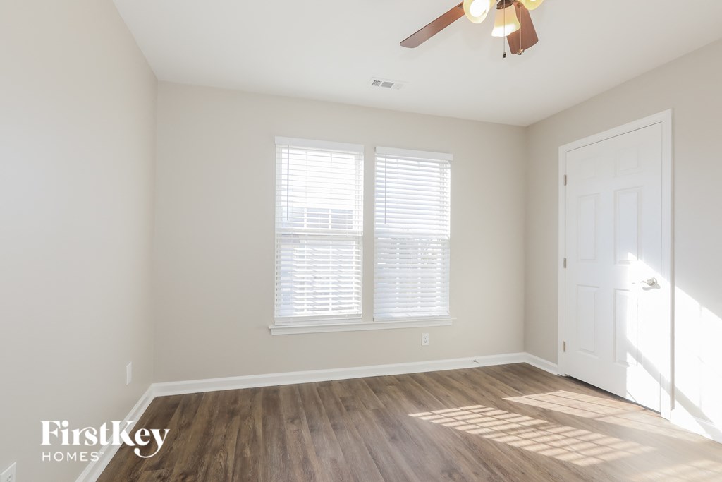 a living room with wood floors and a ceiling fan