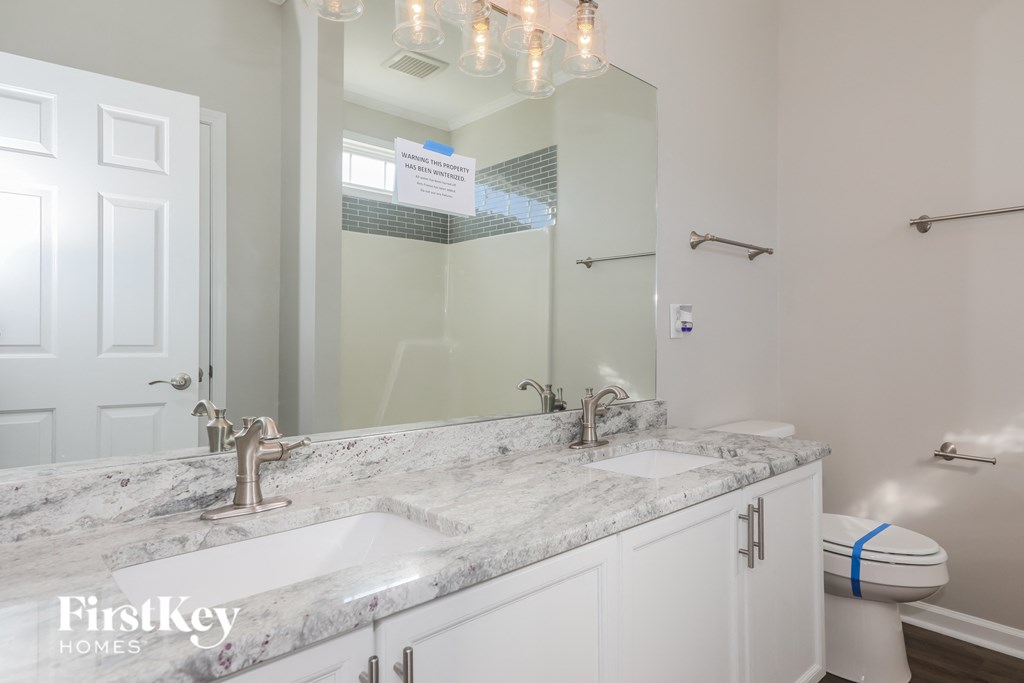 a white bathroom with two sinks and a mirror