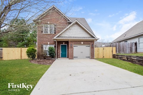 a brick house with a white garage and a white driveway